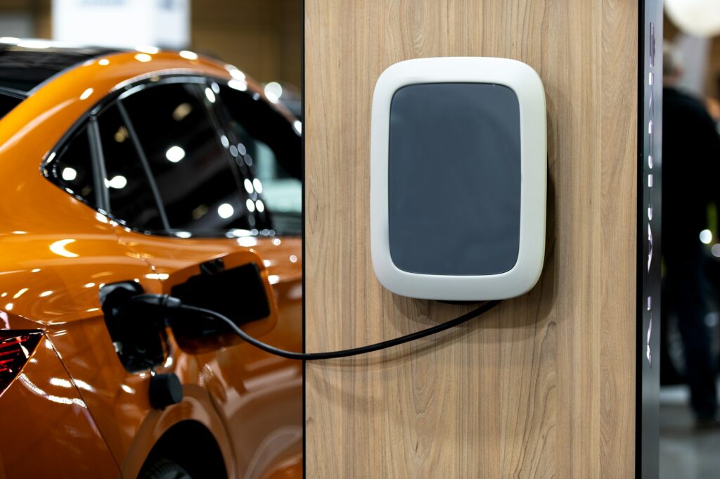 Closeup of power supply plugged into an modern electric car. Electric or EV car charging station.